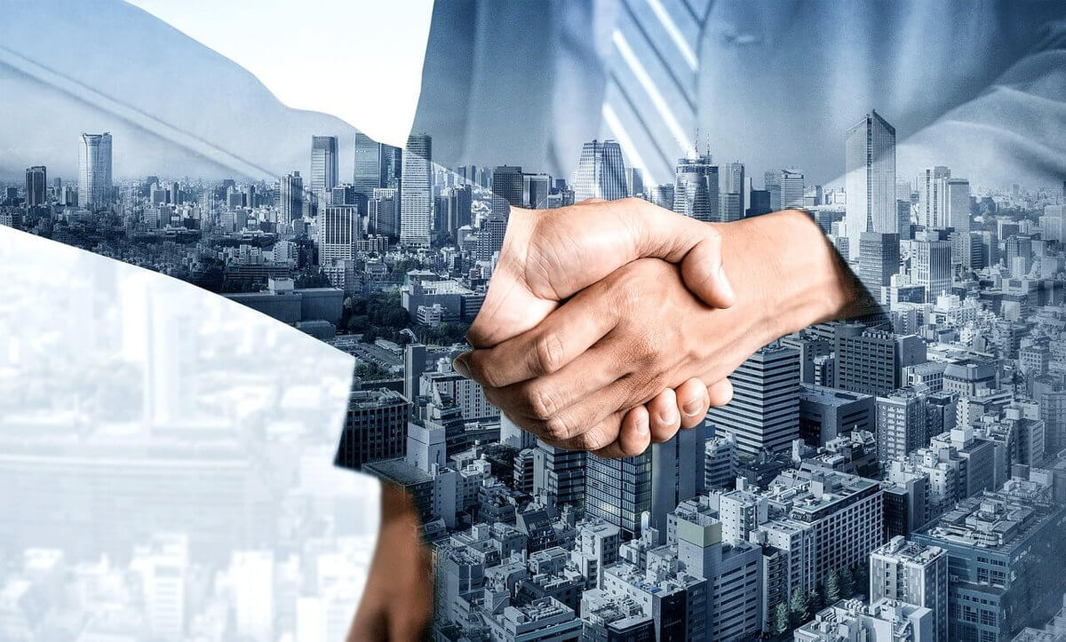 a handshake with buildings in the background, illustrating a successful real estate investment deal