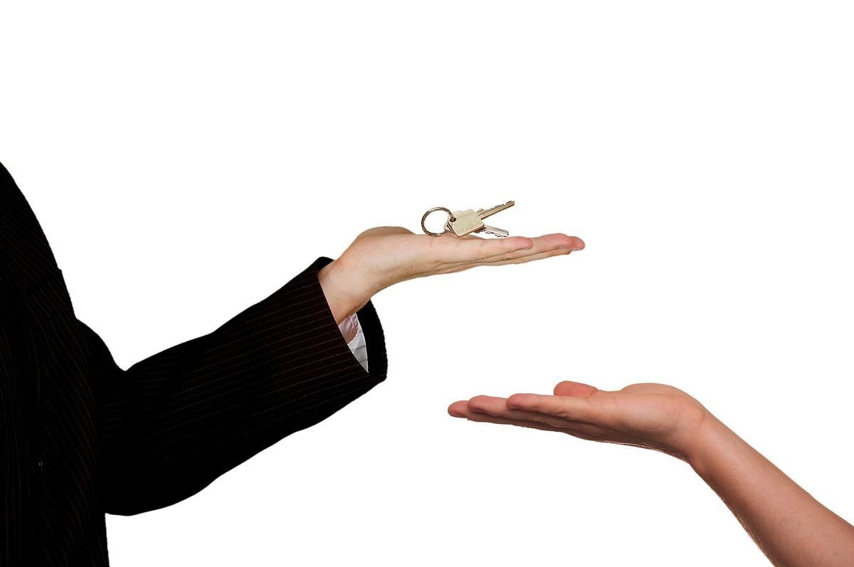 a property owner handing a key to a renter or tenant