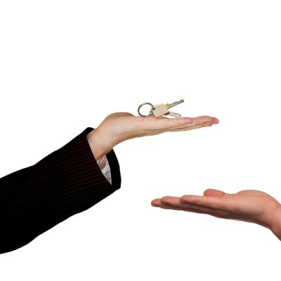 a property owner handing a key to a renter or tenant