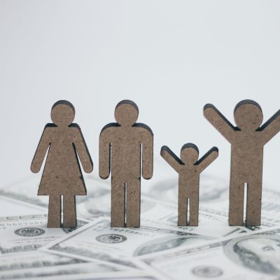 small cardboard cut-outs of people resembling family members on top of dollar bills